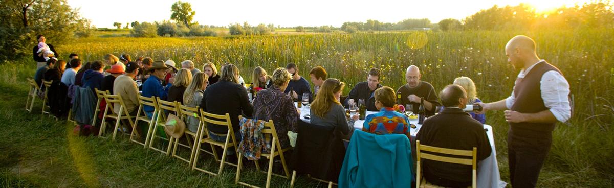 People sitting at a long rectangular table during a Boulder Farm Dinner