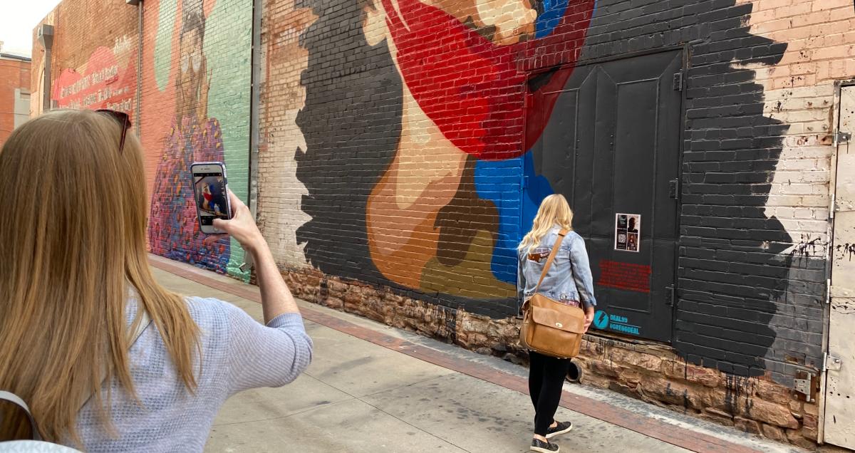 Women taking pictures of the Street Wise Murals Behind Boulder Theater